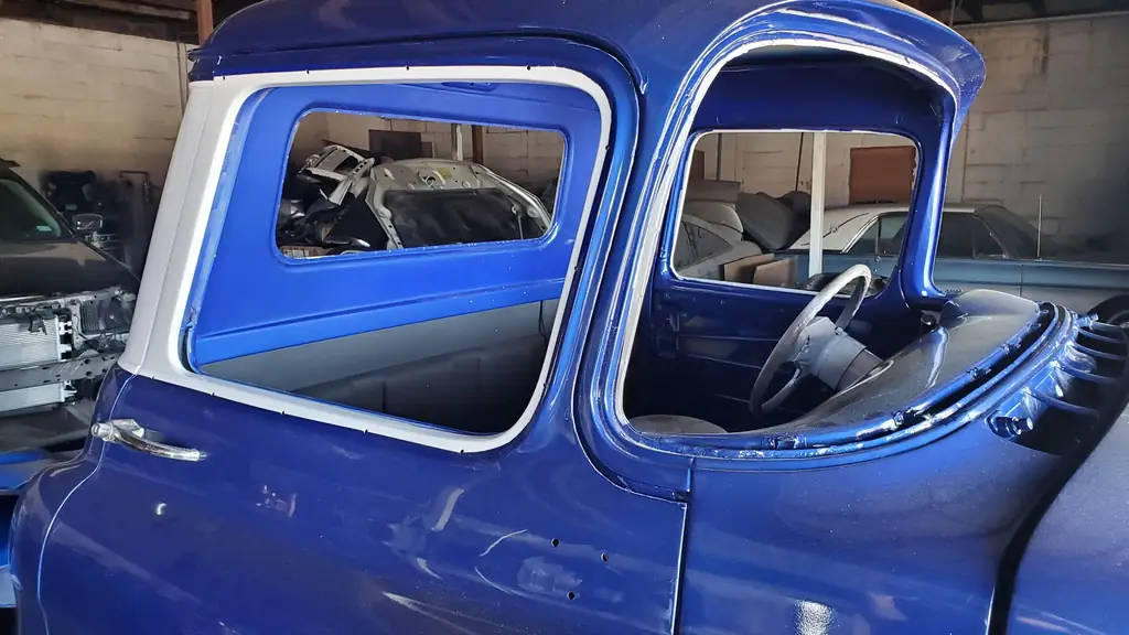 Wet-look two-tone blue and white paint on the finished cab, inside the shop